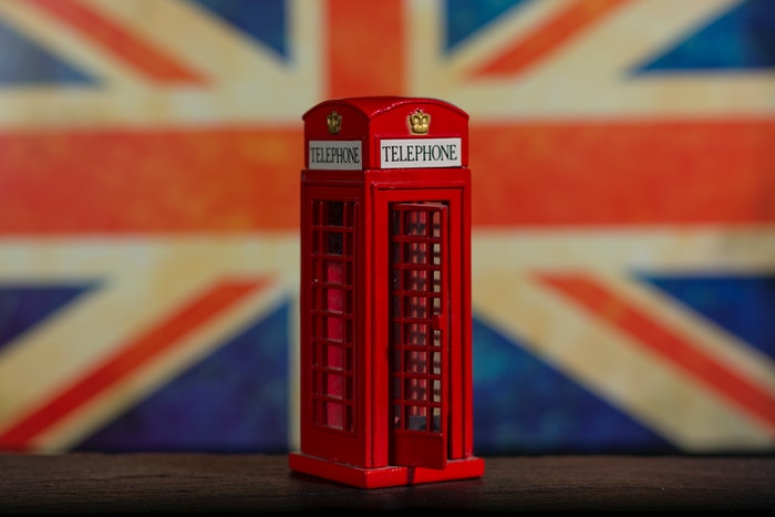 Red toy phone booth with british flag background