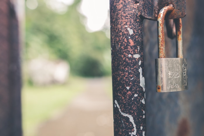 A lock on a rusty fence