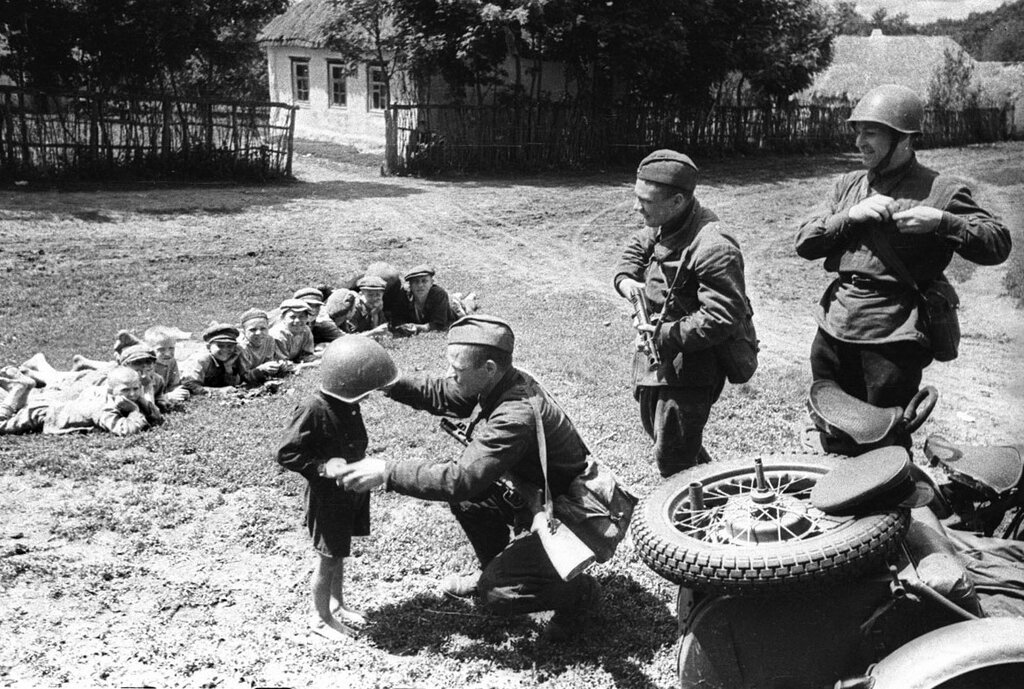 Солдаты 51-го отдельного мотоциклетного батальона 22-го танкового корпуса 38-й армии Юго-Западного фронта с советскими детьми. 1942 г.